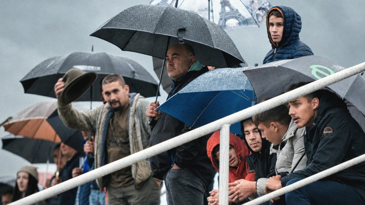 Gledatelji pod kišobranima na lokalnoj nogometnoj utakmici podno Petrove gore