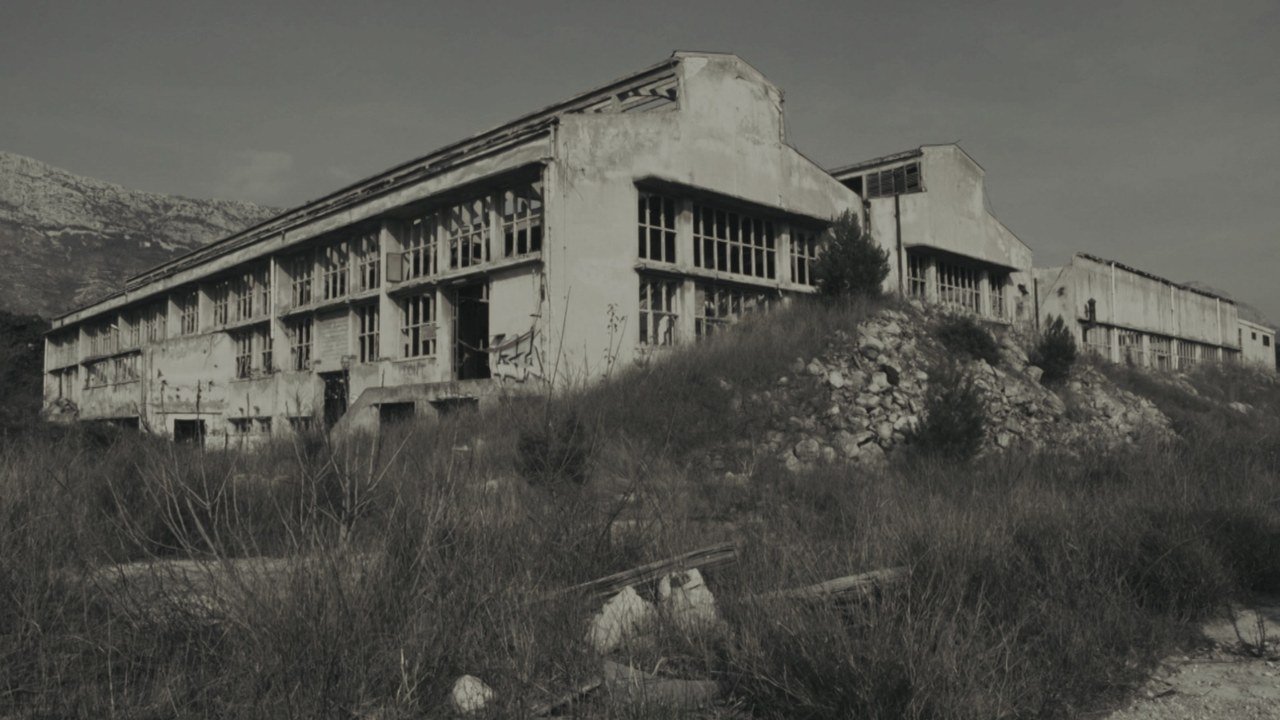 An abandoned industrial complex beneath the mountains