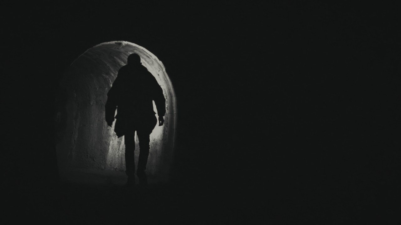 A lone silhouette inside a dark tunnel